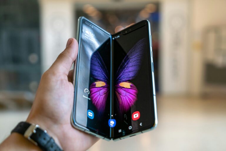 Halb aufgeklapptes Samsung Galaxy Z Fold in einer Hand mit sichtbarem Innendisplay und farbigem Hintergrundbild